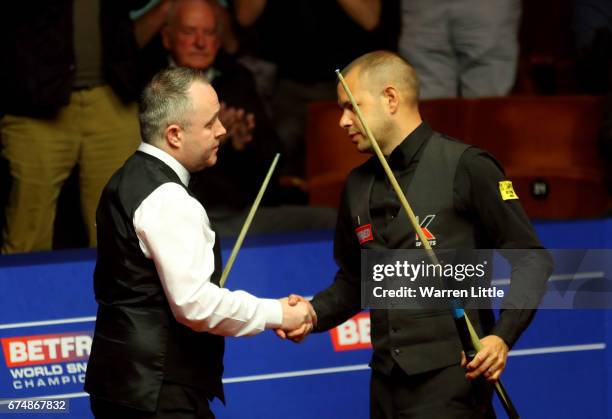 John Higgins of Scotland is congratulated by Barry Hawkins of England after winning their semi final match on day fifteen of Betfred World...