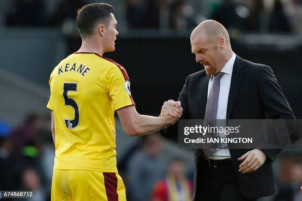 Burnley's English manager Sean Dyche congratulates Burnley's English defender Michael Keane after the English Premier League football match between...