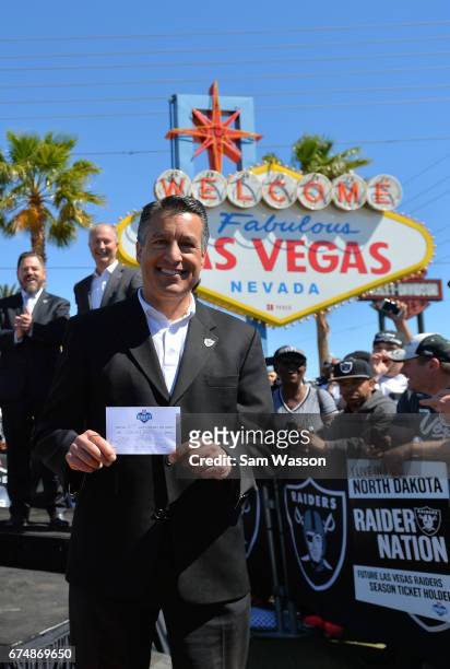 Nevada Gov. Brian Sandoval holds up the Oakland Raiders' fourth-round draft pick card during the team's 2017 NFL Draft event at the Welcome to...