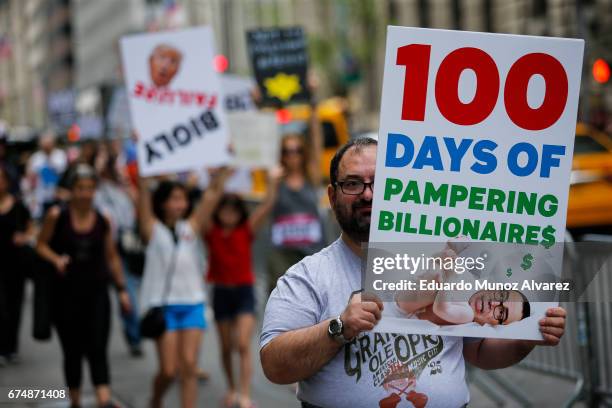 People march against US president Donald Trump as they take part in the '100 Days of Failure' protest on April 29, 2017 in New York City. Activists...