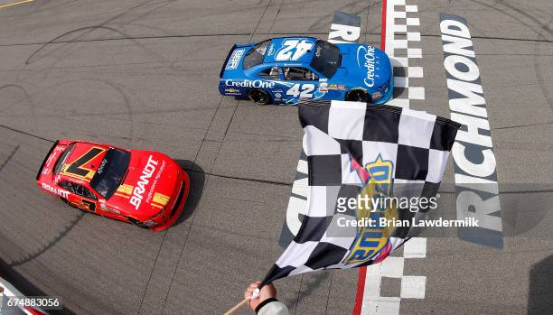 Kyle Larson, driver of the Credit One Bank Chevrolet, takes the checkered flag as Justin Allgaier, driver of the BRANDT Chevrolet, places second...