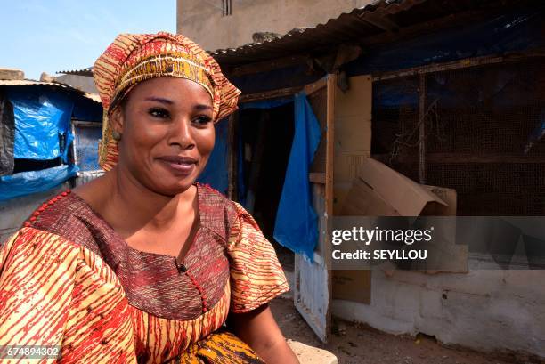 Fifty-year-old Senegalese Ndeye Khari Pouye, sits outside her chicken coup on March 16 in Grand-Mbao, financed with the money she won in the...