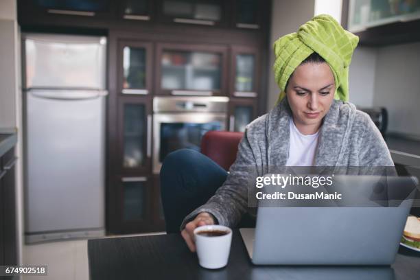 beautiful woman in bath towel using laptop - woman in bathrobe stock pictures, royalty-free photos & images