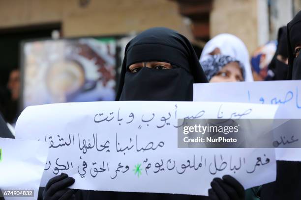 Palestinian women hold placards during a protest demanding end an Israeli blockade of the Gaza Strip, at Al-Shifa hospital in Gaza City on April 29,...