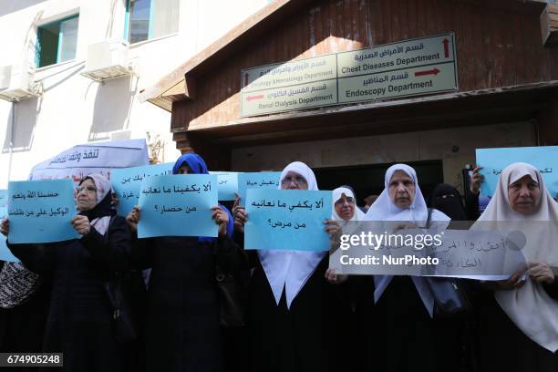 Palestinian women hold placards during a protest demanding end an Israeli blockade of the Gaza Strip, at Al-Shifa hospital in Gaza City on April 29,...