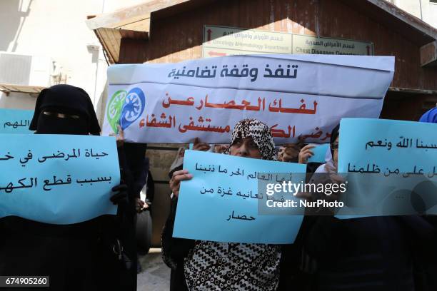 Palestinian women hold placards during a protest demanding end an Israeli blockade of the Gaza Strip, at Al-Shifa hospital in Gaza City on April 29,...