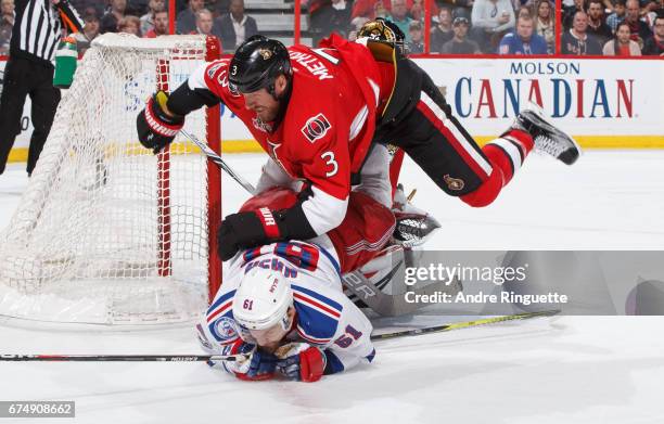 Marc Methot of the Ottawa Senators knocks Rick Nash of the New York Rangers to the ice to clear the crease in Game Two of the Eastern Conference...