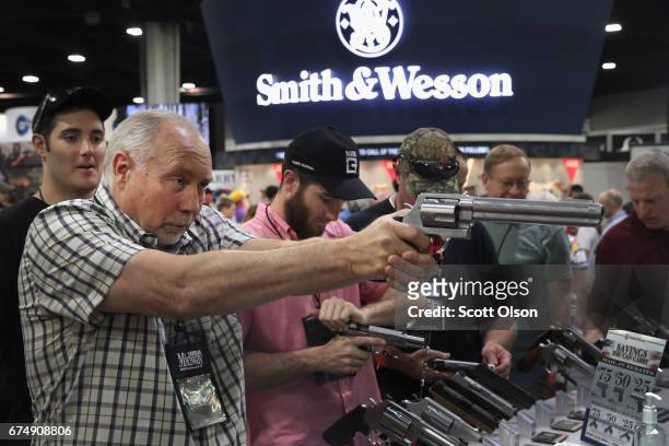 National Rifle Association members look over pistols in the Smith & Wesson display at the 146th NRA Annual Meetings & Exhibits on April 29, 2017 in...