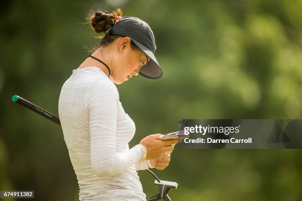 Michelle Wie of the United States checks her yardage book at the eighth green during the third round of the Volunteers of America North Texas...