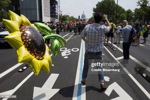 Demonstrator holds a flower balloon on Pennsylvania Avenue during the People's Climate Movement March in Washington, D.C., U.S., on Saturday, April...