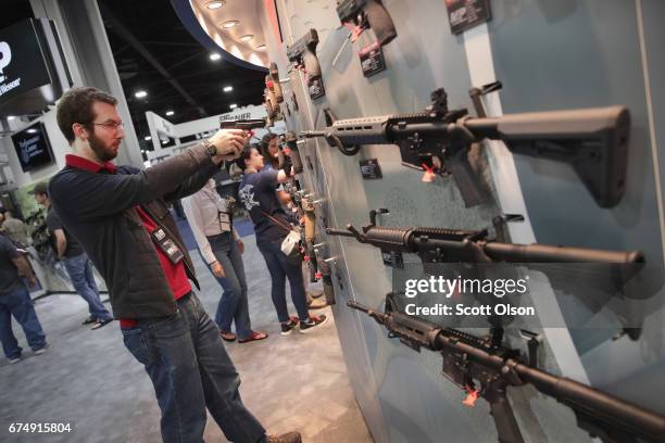 National Rifle Association members look over guns in the Smith & Wesson display at the 146th NRA Annual Meetings & Exhibits on April 29, 2017 in...