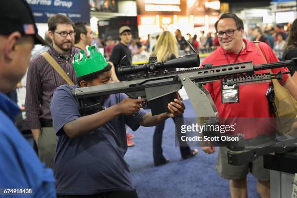 National Rifle Association members look over guns in the Barrett display at the 146th NRA Annual Meetings & Exhibits on April 29, 2017 in Atlanta,...