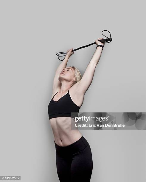 woman in work-out clothes stretching with jump rop - eric van den brulle ストックフォトと画像