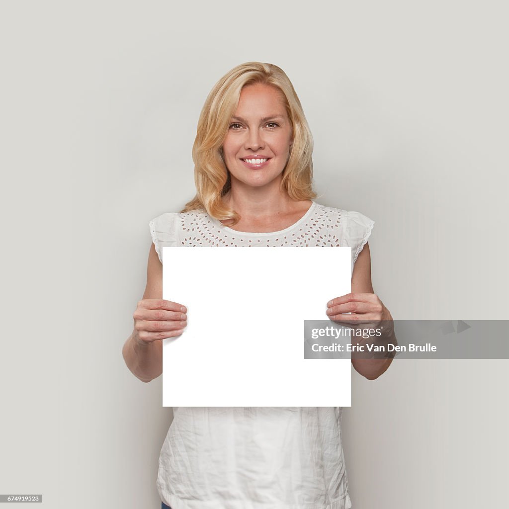 Blonde woman holding white card