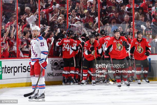 Dion Phaneuf and Mike Hoffman of the Ottawa Senators celebrate their overtime win as Derek Stepan of the New York Rangers sates off the ice in Game...
