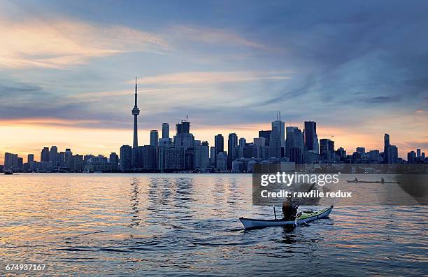 a kayaker in front of a city skyline - toronto photos et images de collection