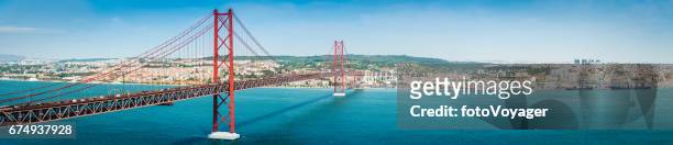 bridge across blue bay to city beyond lisbon panorama portugal - lisbon stock pictures, royalty-free photos & images