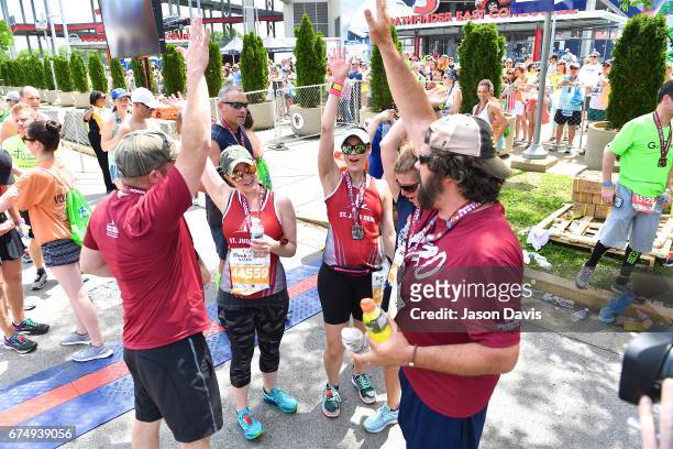 Participants Denise Drucker, Dena Mannos, Katy Drucker, Megan Xidas, Amy Drucker and Tim Kelly celebrate after they cross the finish line during the...