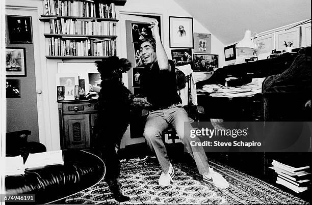American stage and film director Gordon Davidson in his home office with his dog, Pacific Palisades, Los Angeles, California, 1980.