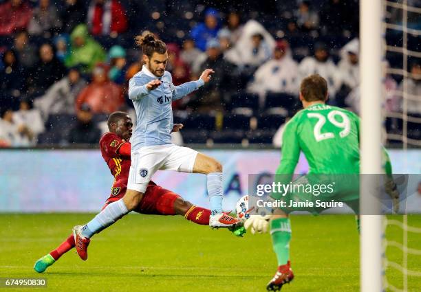 Graham Zusi of Sporting Kansas City defends against a shot on goal by Demar Phillips of Real Salt Lake as goalkeeper Tim Melia looks on during the...