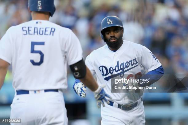 Leadoff batter Andrew Toles of the Los Angeles Dodgers is greeted by on deck batter Corey Seager as he returns to the dugout after hitting a solo...