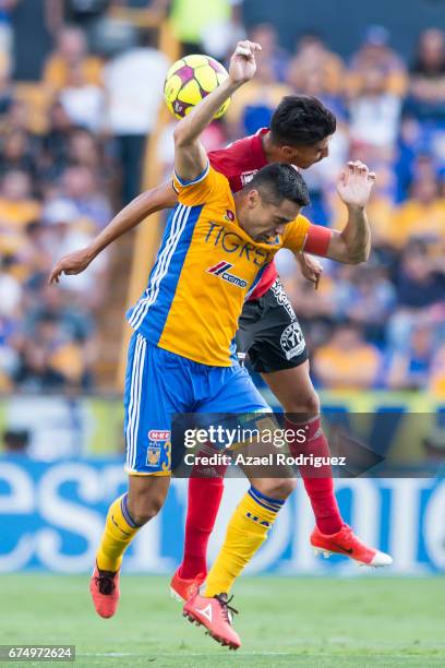 Juninho of Tigres heads the ball with Juan Lucero of Tijuana during the 16th round match between Tigres UANL and Tijuana as part of the Torneo...