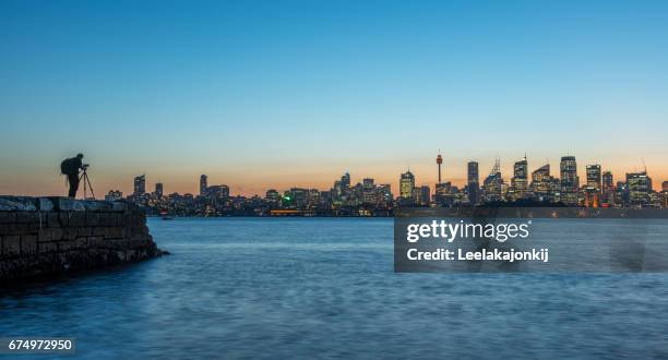 photographer with sydney view in background. - ports nsw stock pictures, royalty-free photos & images