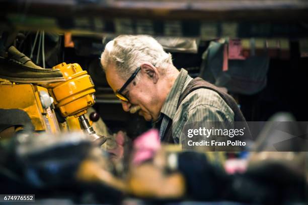 senior man in his shoe repair shop. - old wise business man white stock-fotos und bilder