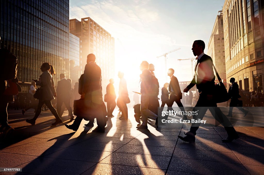 Employees walking to work in the city at sunrise