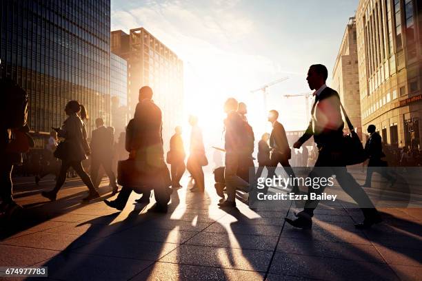 employees walking to work in the city at sunrise - motivatie stockfoto's en -beelden