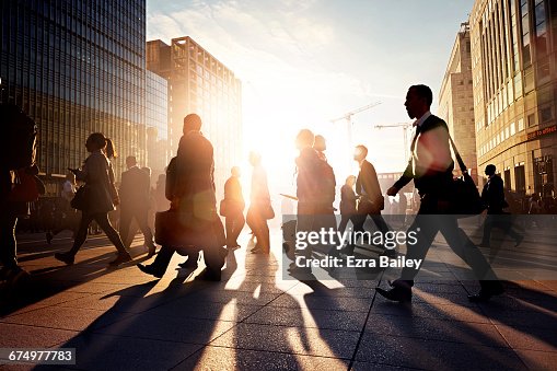 Employees walking to work in the city at sunrise Employees walking to work in the city at sunrise