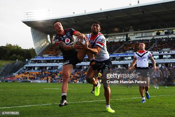 Charnze Nicoll-Klokstad of the Warriors competes with Daniel Tupou of the Roosters for the ball during the round nine NRL match between the New...