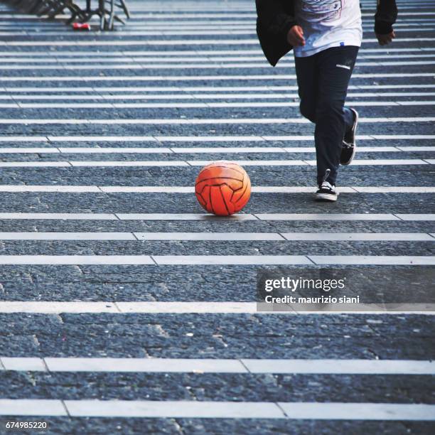 children playing with soccer ball on road - attrezzatura sportiva imagens e fotografias de stock