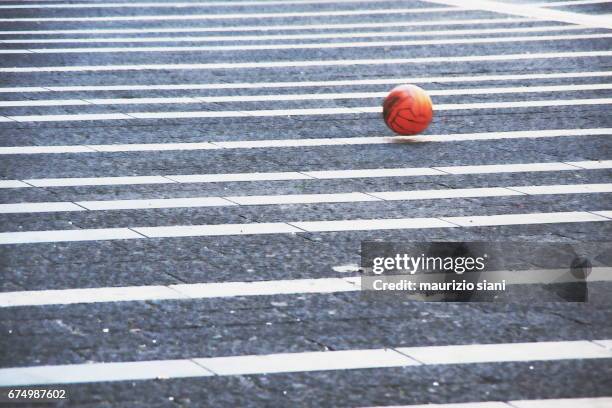 a football bouncing across the street - pallone da calcio stockfoto's en -beelden