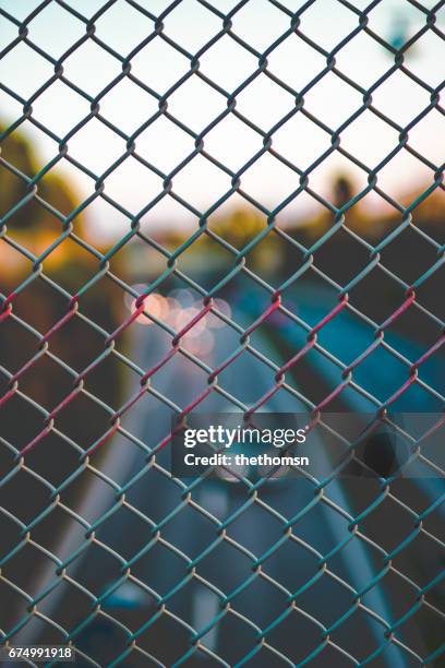 blurred highway traffic thru a fence at sundown, germany - verkehrswesen stock pictures, royalty-free photos & images