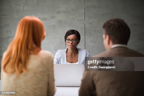 financieel adviseur van de bank in gesprek met paar - ginger banks stockfoto's en -beelden