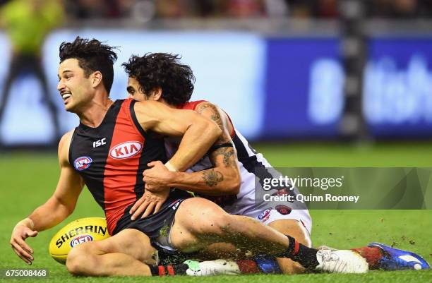 Conor McKenna of the Bombers is tackled by Jeff Garlett of the Demons during the round six AFL match between the Essendon Bombers and the Melbourne...