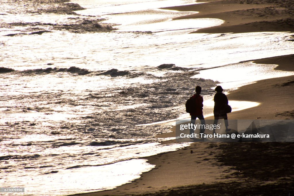 Lovers walking on the sunset beach