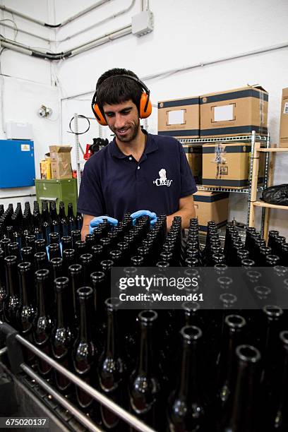 man working in beer bottling plant - bierflaschen fließband stock-fotos und bilder