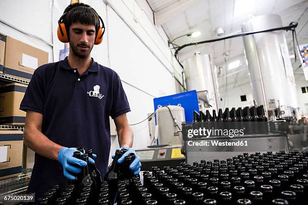 man working in beer bottling plant - bierflaschen fließband stock-fotos und bilder