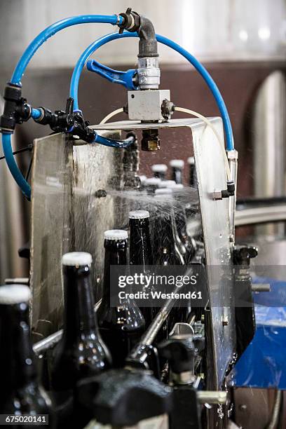 beer bottles on conveyor belt in bottling plant - beer bottle stock pictures, royalty-free photos & images