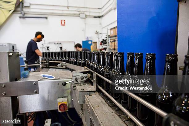 men working in beer bottling plant - bierflaschen fließband stock-fotos und bilder