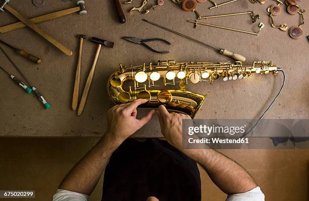 instrument maker repairing a saxophone - woodwind instrument stock pictures, royalty-free photos & images