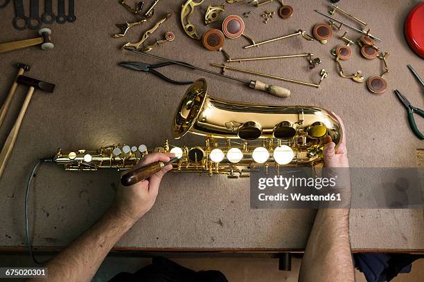 instrument maker repairing a saxophone - musical instrument repair stock pictures, royalty-free photos & images
