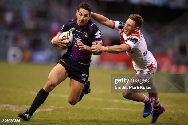 Billy Slater of the Storm evades the tackle of Kurt Mann of the Dragons during the round nine NRL match between the St George Illawarra Dragons and...