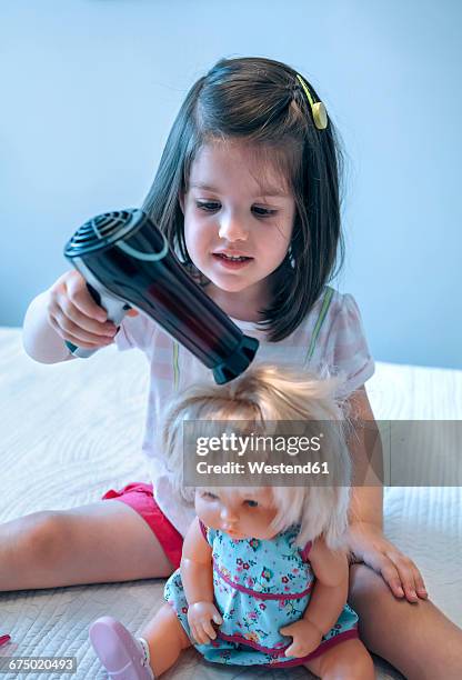 girl blow-drying hair of doll - dolls ストックフォトと画像