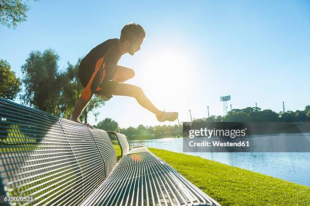 athlete jumping over bench at the riverside - free running stock pictures, royalty-free photos & images