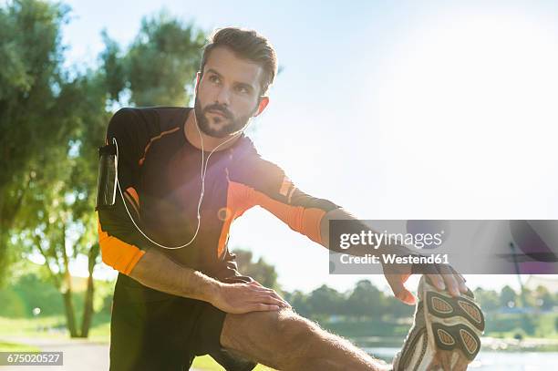 athlete stretching - jogging park stock-fotos und bilder