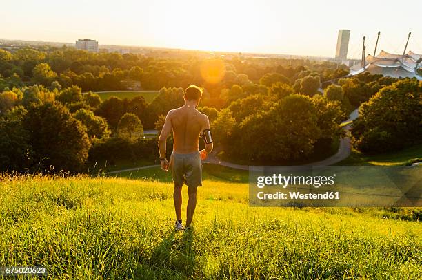 barechested athlete on meadow in park at sunset - semi dress stock pictures, royalty-free photos & images