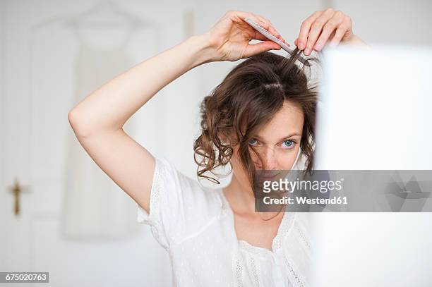 woman at home doing her hair - combing ストックフォトと画像